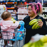 A foster mom is grocery shopping with two young children